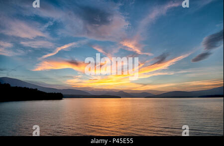 Tramonto spettacolare con cielo blu al serbatoio Ashokan in Ulster County in New York. Luce dorata si riflette sulle montagne e calma la superficie del serbatoio Foto Stock