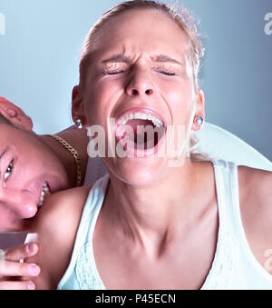 Ragazzo violento morso donne spalla, donna screeming Foto Stock