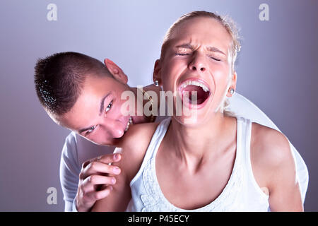 Ragazzo violento morso donne spalla, donna screeming Foto Stock