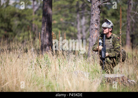 Un soldato da la quarantunesima brigata canadese Gruppo, esercito canadese, prende un ginocchio prima di spostare fuori su una pattuglia a urban patrol corsia di formazione come parte del Golden Coyote esercizio, West Camp rapido, S.D., 16 giugno 2016. Il Golden Coyote è un esercizio a tre-fase, scenario di esercizio di condotta condotta in Black Hills del Sud Dakota e Wyoming, quali comandanti permette di concentrarsi sulla missione requisiti essenziali per lo svolgimento delle attività e le attività del guerriero e punte di battaglia. (U.S. Esercito foto di Spc. Kristen Root/rilasciato) Foto Stock