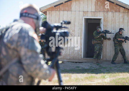 U.S soldato dell'esercito Spc. Austin Pearce della 129Mobile degli affari pubblici distacco, South Dakota Guardia nazionale, documenti soldati canadesi della 41ª Brigata canadese Gruppo, camere di compensazione durante la pattuglia urbana corsia di formazione come parte del Golden Coyote esercizio, West Camp rapido, S.D., 16 giugno 2016. Il Golden Coyote è un esercizio a tre-fase, scenario di esercizio di condotta condotta in Black Hills del Sud Dakota e Wyoming, quali comandanti permette di concentrarsi sulla missione requisiti essenziali per lo svolgimento delle attività e le attività del guerriero e punte di battaglia. (U.S. Esercito foto di Spc. Kristen Root/rilasciato) Foto Stock