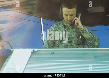 Stati Uniti Air Force Tech. Sgt. Dallas Bloss, 379 Expeditionary Operations Support Squadron, NCO in carica della formazione e standardizzazione, parla con una persona che ha contattato la torre per ulteriori indicazioni di Al Udeid Air Base, Qatar, 13 giugno 2016. In aggiunta al monitoraggio USAF di controllo del traffico aereo i membri, Dallas, un nativo della città di Gas Ind., supporta le forze della coalizione che condividono la torre. (U.S. Air Force foto di Senior Airman Kimberly Nagle) Foto Stock