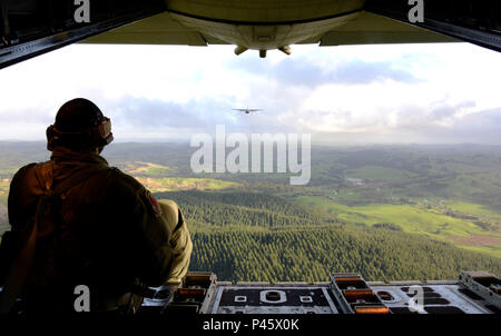 Un primo Special Operations Squadron loadmaster siede sul retro di un MC-130H Combat Talon II e orologi a Royal New Zealand Air Force C-130 Hercules durante una formazione dissimili a basso livello di volo 23 Giugno 2016. Membri provenienti da 353 Special Operations Group ha partecipato in teak di esercizio al netto del 12 giugno fino al 30 giugno in Whenuapai, Nuova Zelanda. Durante l'esercizio, i membri sia dalla Nuova Zelanda Forza di Difesa degli Stati Uniti e Air Force ha lavorato insieme per condurre il personale e le apparecchiature aria scende insieme mentre lo scambio di nuove tecniche. (U.S. Air Force foto di Master Sgt. Kristine Dreyer, 353 così Foto Stock