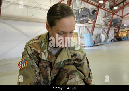 Stati Uniti Army Spc. Kristen Root, chi è assegnato il combattimento 982nd fotocamera Company, prepara il cablaggio che ella si usurano mentre sul bordo della CH47-Chinook. Root e è stata la documentazione di una missione da parte del Singapore Air Force nel Ellsworth Air Base, S.D., 14 giugno 2016. (U.S. Esercito Foto di Sgt. Alfonso Corral) Foto Stock