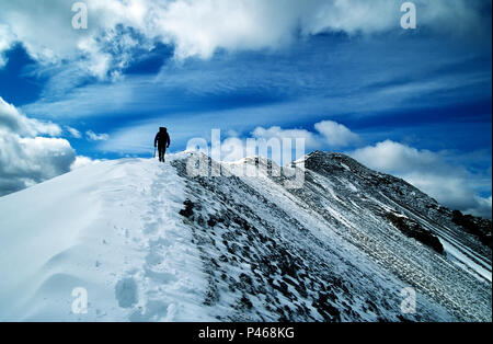 Un scalatore sul vertice lungo il crinale di un Beinn Bheithir nelle Highlands scozzesi, Scozia Foto Stock