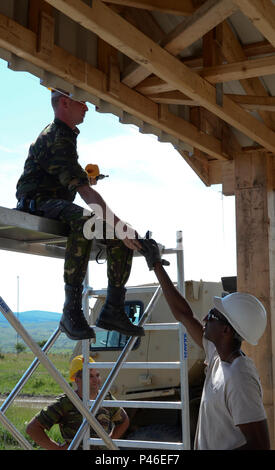 Spc. Qjuamdi Walker (a destra), 166Engineer Company, Alabama Guardia nazionale, mani Cpl. Levente Nema, Rumeno Forze terrestri, una batteria per il trapano cordless per il bloccaggio nelle sezioni di metallo per la vela in un padiglione sulla piccola gamma di armi a Cincu Training Center, Romania, 16 giugno 2016. La 166Engineer Company è una Alabama nazionale unità di guardia che partecipano al castello risoluto 16, una multinazionale il funzionamento congiunto del miglioramento delle infrastrutture su basi alleate nella parte orientale della regione europea. (Esercito Foto di Staff Sgt. Christopher Davis, 226th manovra Brigata Enhancement, Alabama Esercito Nazionale Foto Stock