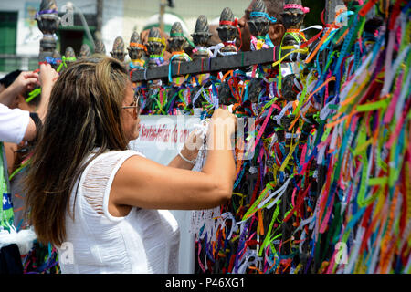 SALVADOR, BA - 26/12/2014: ÚLTIMA SEXTA-FEIRA DO ANO EM SALVADOR - (Amarrando fitinha do Bonfim e fazendo pedidos. Tradição nos gradis da igreja) Na última Sexta-feira do ano, em Salvador, fiéis sobem una colina Sagrada para pedir bençãos e agradecer ao Senhor do Bonfim, na Igreja do Bonfim. Para os devotos fare candomblé una sexta-feira é o dia dedicado ao orixá Oxalá, que no sincretismo é o Senhor do Bonfim - Gesù. Neste dia, veste-se o branco em reverência ao pai maior dos Orixás, Oxalá. Várias missas campais são celebradas duranti o dia, desde come cinco da manhã. Em frente a igreja, há também come Foto Stock