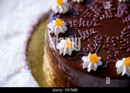 Torta al cioccolato con fiori di colore bianco con crema di close-up. Foto Stock