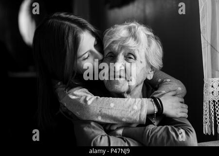 Una bambina abbraccia la nonna. Foto in bianco e nero. Foto Stock