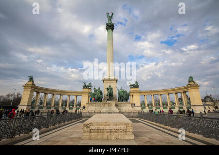 BUDAPEST, Ungheria - 7 Aprile 2017: Piazza degli Eroi (Hosok tere) di Budapest, Ungheria, al tramonto, con turisti arrampicata la statua principale e Pict di colonna Foto Stock