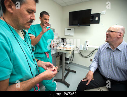 Col. Jose Villalobos (sinistra), 59A Gruppo dentale protesi maxillo-facciale direttore di programma e il Mag. Stephen Cherrington (centro), 59A Gruppo dentale prosthodontist maxillo-facciale, discutere esercito pensionato Master Sgt. Todd Nelson è di nuovo orecchio protesico a San Antonio il militare Centro Medico, Base comune San Antonio-Fort Sam Houston, Texas, 28 giugno. La cinquantanovesima ala medica della protesi maxillo-facciale dipartimento è uno dei pochi nel dipartimento della difesa che crea protesi di parti del corpo come gli occhi, le orecchie e il naso. (U.S. Air Force foto/Staff Sgt. Kevin Iinuma) Foto Stock
