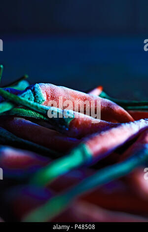 Vista laterale di un gruppo di piccole ROSSO PEPERONCINO congelati in una cucina in attesa di essere cotti Foto Stock