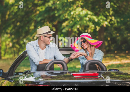 Coppia giovane in amore per godere nella loro autovettura convertibile in natura. Foto Stock