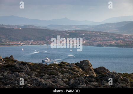 Vista dall'isola italiana di La Maddalena a Palau sull'isola italiana di Sardegna con traghetti e battelli vela avanti e indietro tra la isla Foto Stock