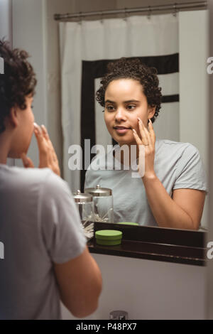 Donna ammirando se stessa davanti allo specchio Foto Stock