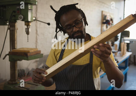 Carpenter guardando tavolato in legno Foto Stock