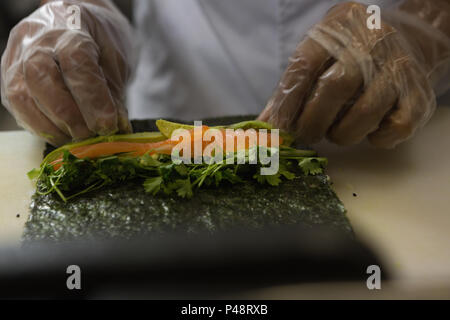 Senior chef prepara sushi in cucina Foto Stock