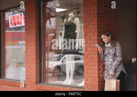 Bella donna utilizzando il telefono cellulare Foto Stock