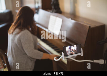 Bellissima femmina vlogger suonando piano Foto Stock