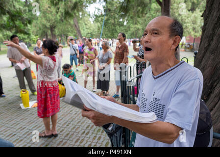 Coro amatoriale canta brani folk sabato mattina nel parco che circonda il Tempio del Cielo a Pechino, Cina Foto Stock