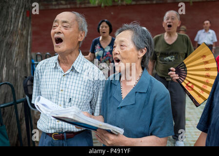 Coro amatoriale canta brani folk sabato mattina nel parco che circonda il Tempio del Cielo a Pechino, Cina Foto Stock