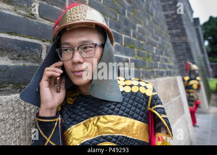 Un attore in costume colloqui sul telefono celular, Tempio di Confucio, Qufu, Provincia di Shandong, Cina Foto Stock