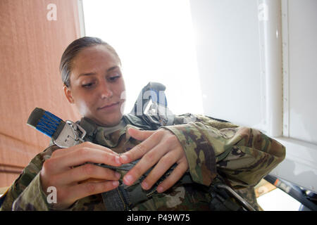 Spc. Kristen Root, 982nd combattere la telecamera, società mette sul suo paracadute elettrico prima di una operazione di volo su San semplice Eglise drop zone vicino a Fort Bragg, N.C. il 25 giugno 2016. La 982ND, un esercito di unità di riserva, fornisce i nostri leader militari e funzionari del governo di prima mano, immagini e video (sia rilasciato e classificate), delle nostre forze in campo. Essi sono gli occhi e le orecchie' del decision maker. (U.S. Foto dell'esercito da Staff Sgt. Felix Fimbres) Foto Stock