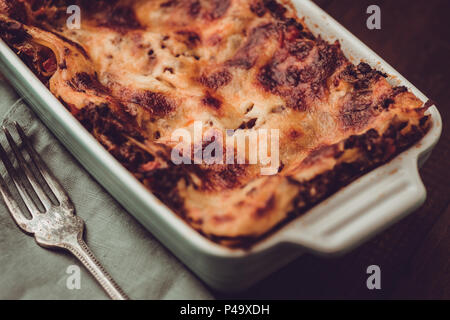 Italian lasagne alla bolognese e Mozzarella su scuro dello sfondo in legno Foto Stock