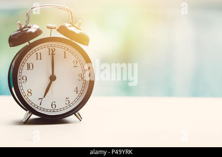 Alle 7 sul quadrante di un orologio orologio retrò presso la piscina all'aperto relax time tempo di vacanza concetto. Foto Stock