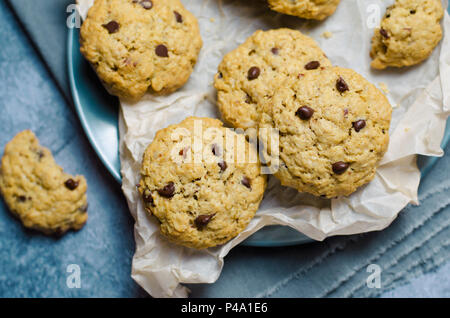 Pane appena sfornato, fiocchi d'avena i biscotti al cioccolato su sfondo blu Foto Stock