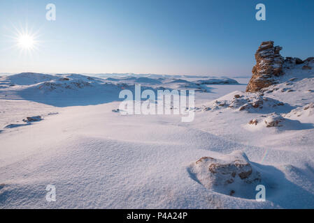 Rocce sotto la neve sul capo Uyuga, il lago Baikal, Regione di Irkutsk, Siberia, Russia Foto Stock