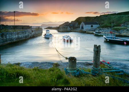 Ballintoy, County Antrim, Irlanda del Nord, Regno Unito. Il 21 giugno, 2018. Solstizio d'estate mattina. Regno Unito meteo, una chiara alba del giorno più lungo dell'anno. Lo spuntar del giorno su Ballintoy Harbour e isola di Rathlin, sulla costa di Causeway, North Antrim, Irlanda del Nord. Credito: John Potter/Alamy Live News Foto Stock