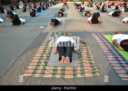 I membri della forza militare di elevare i loro piedi mentre si posa sulla terra durante la sessione di yoga. I soldati delle forze paramilitari (l Assam Riffals) fare yoga in occasione del World Yoga giorno al loro accampamento di Agartala, capitale del nord-est stato di Tripura, India. Giornata Internazionale di Yoga, o comunemente e Nazioni Unite ufficialmente indicato come giorno di Yoga, viene celebrata ogni anno il 21 giugno sin dal suo inizio nel 2015. Una giornata internazionale di yoga è stato dichiarato all'unanimità dall'Assemblea generale delle Nazioni Unite (AGNU). Questo anno lo Yoga giorno il tema è "Yoga per la pace". Foto Stock