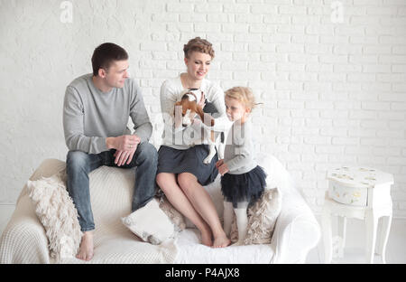 Ritratto di genitori felici con la loro figlia e amato pet con un soggiorno.foto con posto per il testo Foto Stock