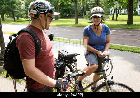 L uomo e la donna in una conversazione mentre prendendo una pausa in un viaggio in bicicletta che indossa caschi. Minneapolis Minnesota MN USA Foto Stock