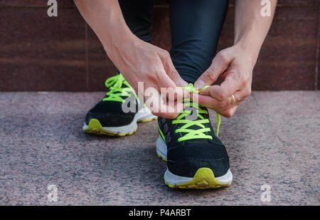 Femmina legatura runner le sue scarpe per preparare a eseguire una corsa all'esterno. Foto Stock