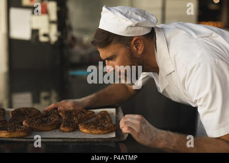 Voce maschile baker controllo pane cotto Foto Stock