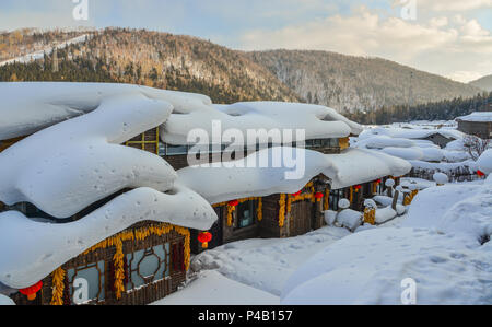 Case di legno coperto di neve al villaggio di montagna a Harbin, Cina. Foto Stock