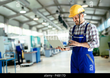 Tecnico che lavora in fabbrica e facendo il controllo di qualità Foto Stock