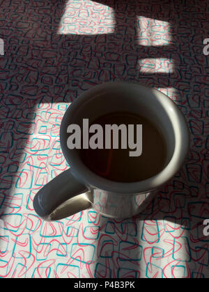 La mattina presto la luce solare getta ombra sulla tazza di caffè seduti sulla tavola di diner, Fargo, il Dakota del Nord Foto Stock