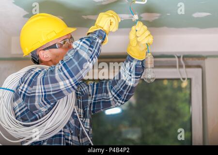 Elettricista tecnico al lavoro in una zona residenziale di impianto  elettrico utilizza la pinza spelafili con le mani protette da guanti Foto  stock - Alamy