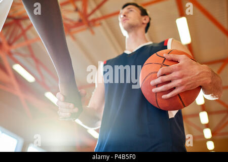 Sportivi senza volto stringono le mani Foto Stock