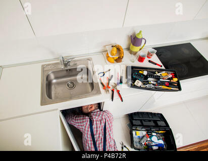 Le riparazioni del lavoratore il problema di perdita nel lavello da cucina Foto Stock