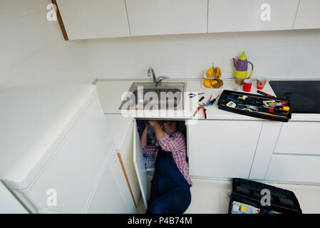 Le riparazioni del lavoratore il problema di perdita nel lavello da cucina Foto Stock