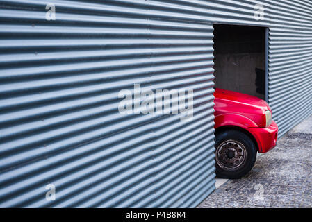 Portogallo Azzorre, isola Sao Miguel, Ponta Delgada, cartone ondulato a parete in acciaio con auto Foto Stock