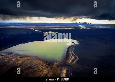 Nuvole di cenere su un piccolo lago con l'Holuhraun eruzione in background. Agosto 29, 2014 una eruzione fissurale avviato in Holuhraun all'estremità nord di un intrusione di magma, che si era spostato progressivamente a nord, dal vulcano Bardarbunga. Bardarbunga è uno stratovulcano situato sotto il Vatnajokull, Islanda più ampia del ghiacciaio. Foto Stock