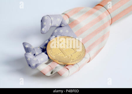 Robot di legno mano con bandiera degli Stati Uniti holding bitcoin su bianco Foto Stock