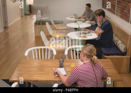 Executive femmina la scrittura sul diario Foto Stock