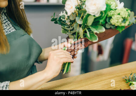 Fiorista femmina decorare fiori freschi di composizione Foto Stock