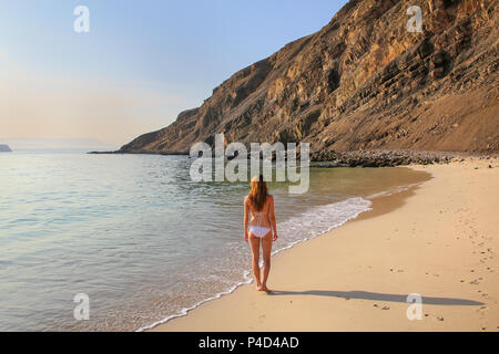 Giovane donna in bikini in piedi presso La Mina spiaggia in Paracas riserva nazionale, Perù. Scopo principale della Riserva è di proteggere ecosistema marino e hist Foto Stock